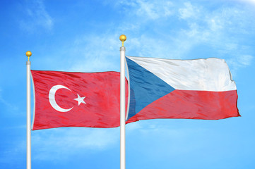 Turkey and Czech Republic two flags on flagpoles and blue cloudy sky