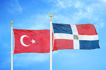 Turkey and Dominican Republic two flags on flagpoles and blue cloudy sky