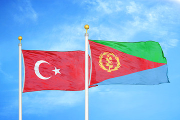 Turkey and Eritrea two flags on flagpoles and blue cloudy sky