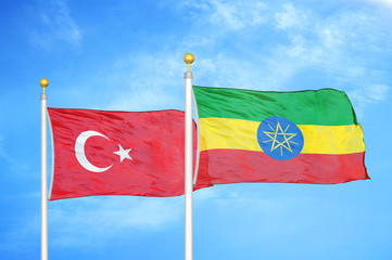 Turkey and Ethiopia two flags on flagpoles and blue cloudy sky