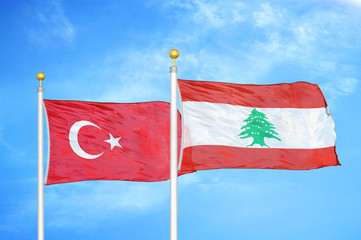 Turkey and Lebanon two flags on flagpoles and blue cloudy sky