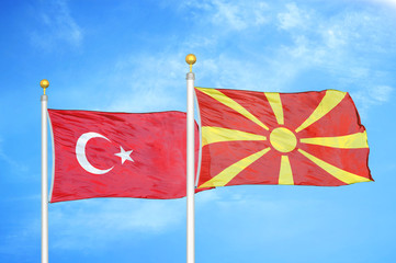 Turkey and North Macedonia two flags on flagpoles and blue cloudy sky