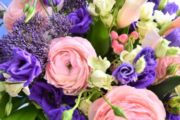 Beautiful pink ranunculus flower with soft focus violet spring flowers and pink decorative berries on background. Elegant bunch of spring flowers. Easter gift. Seasonal spring flowers