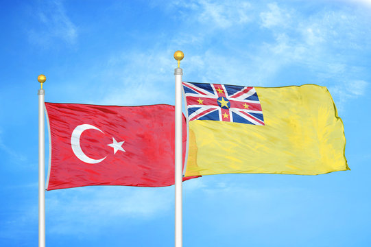 Turkey and Niue two flags on flagpoles and blue cloudy sky