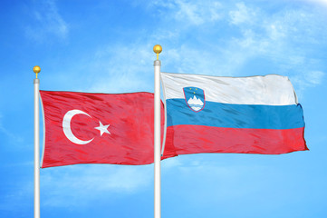 Turkey and Slovenia two flags on flagpoles and blue cloudy sky