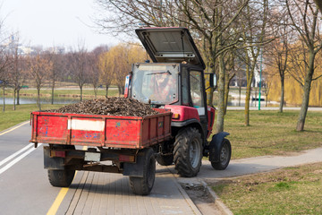 Obraz premium Tractor driven leaves from cleaning city streets, spring cleaning city streets