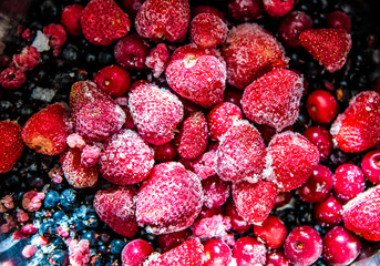 raspberries background. Bright frozen berries. Scattered frozen red strawberries.