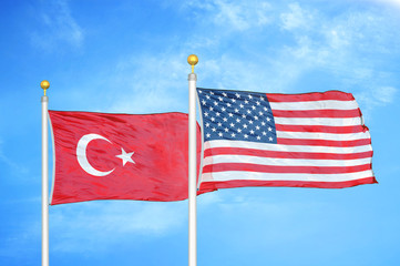 Turkey and United States two flags on flagpoles and blue cloudy sky
