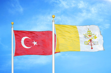 Turkey and Vatican two flags on flagpoles and blue cloudy sky