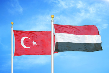 Turkey and Yemen two flags on flagpoles and blue cloudy sky