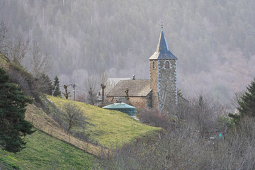 Fototapeta premium Views of the church of Mont in Vielha with snowy mountains in the background.