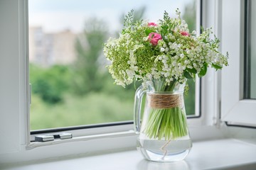 Springtime, spring fresh bouquet of lilies of the valley, pink roses, blooming viburnum