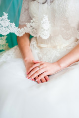 Obraz na płótnie Canvas The bride folded her hands on her dress