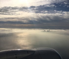 Fototapeta na wymiar Chicago peaking through the mist from airplane window