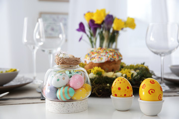 Festive Easter table setting with beautiful decorative eggs indoors