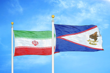 Iran and American Samoa two flags on flagpoles and blue cloudy sky
