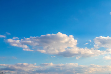 Naklejka premium Light blue sky with white curly clouds_