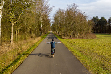 Obraz premium Man riding a bicycle with open arms