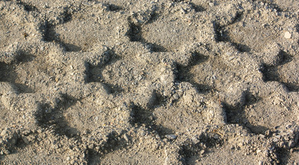 Truck or tractor tire tessellation pattern formed in the dirt.