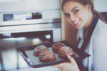 Woman cook holding plate with homemade baked goods