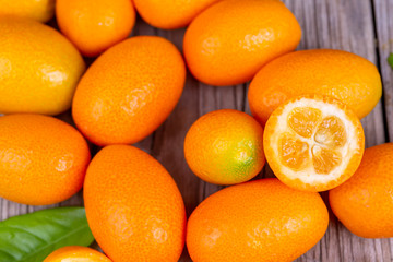 Top view of bunch of fresh kumquats in the organic food market. Some kumquats is cutted.