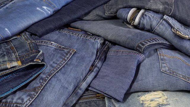 4K view of a pile of jeans clothes fall denim pants