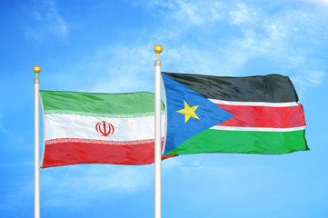 Iran and South Sudan two flags on flagpoles and blue cloudy sky
