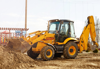 Working excavator tractor digging a trench at construction site