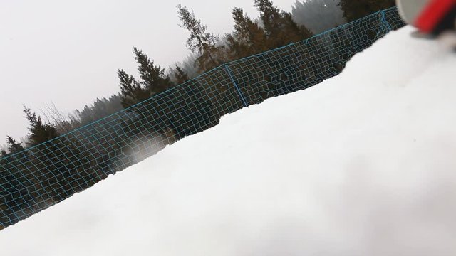 Skier beginner first lessons on the snowy ski slope. Active man loosing a balance and bumping into video camera making a funny accident.