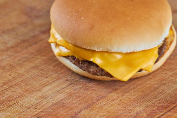 thin cheeseburger or hamburger on a wooden board with diagonal lines background.selective focus. copy space.