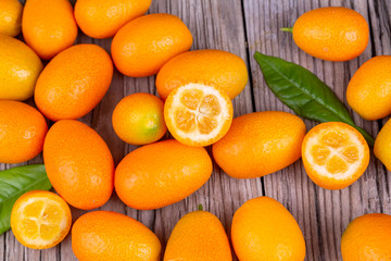 Top view of bunch of fresh kumquats in the organic food market. Some kumquats is cutted.