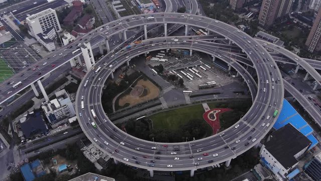 Circular junction at end of Nanpu bridge, aerial orbiting shot. Light traffic at inner ring road of Shanghai. Interesting construction of elevated interchange, large ring with slipways