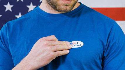 Man putting on I Voted sticker for Presidential election 2020 in America.
