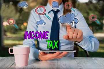 Conceptual hand writing showing Income Tax. Concept meaning Annual charge levied on both earned and...