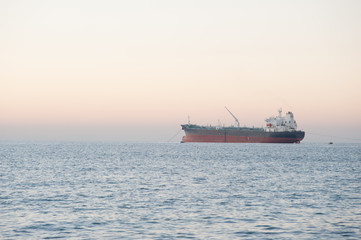 Cargo at sea. Cargo ship at sea on sunset background.