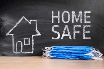 Medical mask on the background of the picture of the house and the inscription home safe