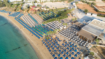Fototapeta premium Aerial bird's eye view of Pantachou - Limanaki beach (Kaliva), Ayia Napa, Famagusta, Cyprus. The landmark tourist attraction bay with golden sand, sunbeds,sea bar restaurants in Agia Napa from above.