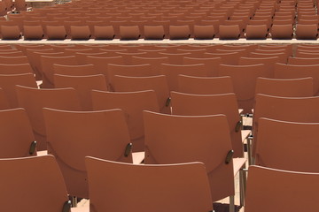 Empty light brown seats at an outdoor festival.