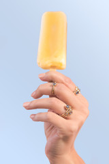Hand holding popsicle with rings on
