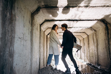 The couple holds hands and walk through the tunnel to the light. The concept