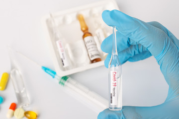 Doctor holds vial with coronavirus vaccine. Concept of Covid-19 vaccination