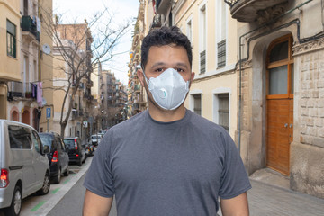 portrait of brunette man in a surgical bandage pff3 on a background of a european buildings coronavirus, illness, infection, quarantine, medical mask