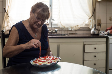 older woman spends her days in quarantine cooking tuna potato salad and mayonnaise with bell peppers