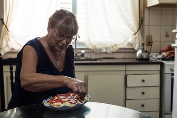 older woman spends her days in quarantine cooking tuna potato salad and mayonnaise with bell peppers