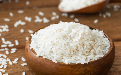 rice grains in bowl on wooden background