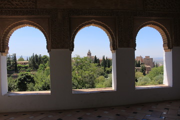 A view of Alhambra palace and fortress complex through a window at Generalife gardens in Granada, Andalusia, Spain.