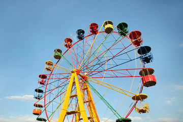 Huge colorful Ferris wheel without people against the blue sky