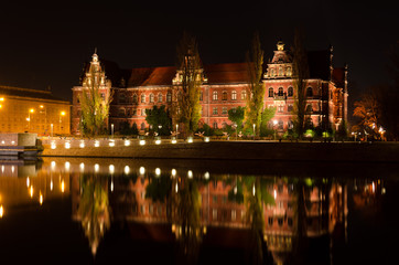 Fototapeta na wymiar National Museum, Muzeum Narodowe, of Wroclaw shoted in the evening and its reflection in Odra river