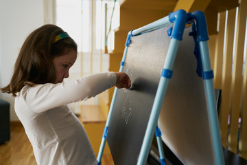 girl draws a virus on the blackboard at home. coronavirus concept