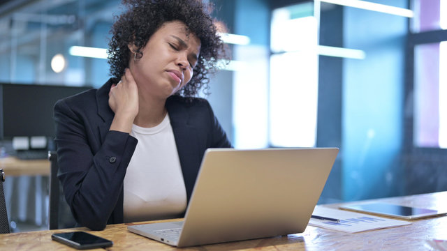 Tired African Businesswoman having Neck Pain at Work